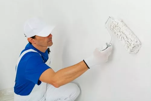 Man painting wall white