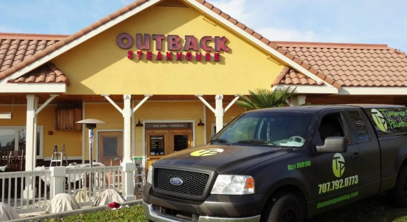 Timmins painting truck in front of Outback Steakhouse after commercial painting project