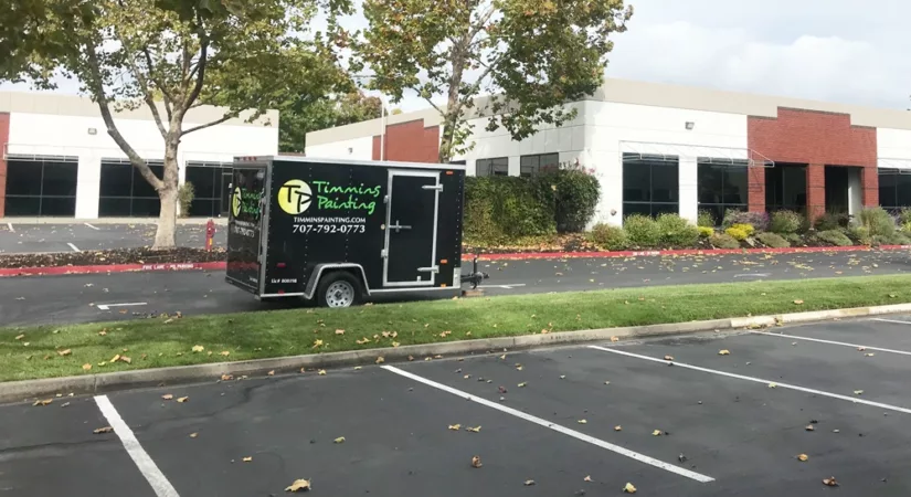 professional painter trailer parked in front of office building read to be painted