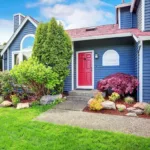 front of freshly painted blue house with red door