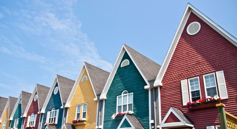Row of matching 2-story houses each painted a different, bright color