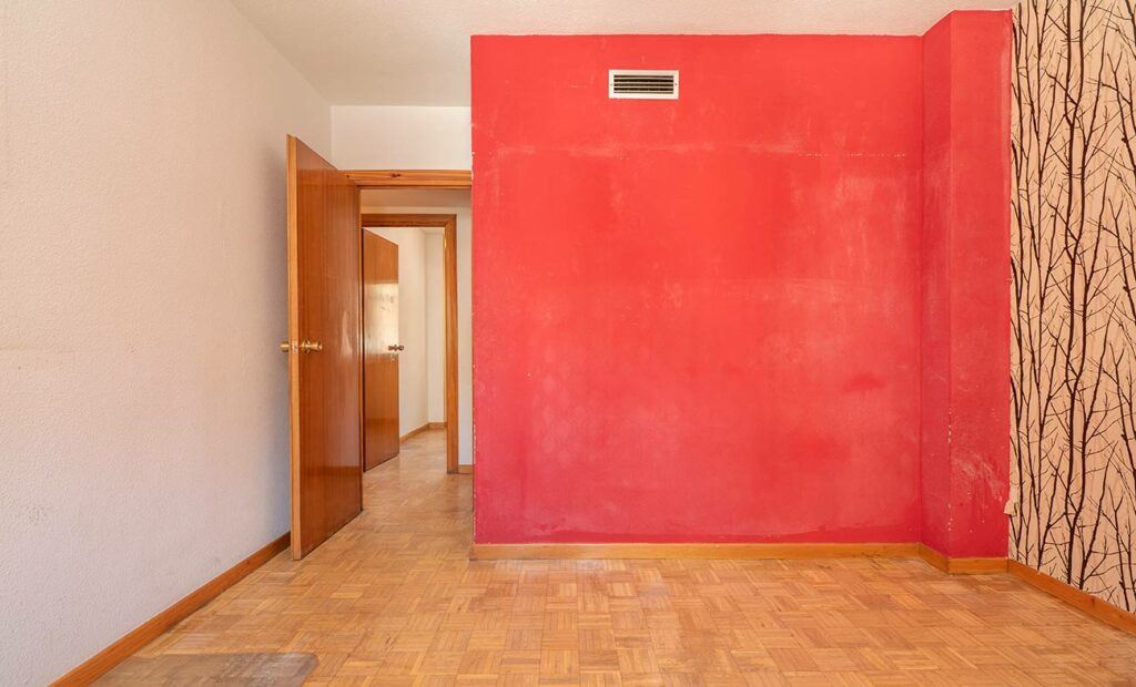 Red wall painted poorly, with white paint showing through. 