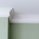 A sage green wall with white interior trim