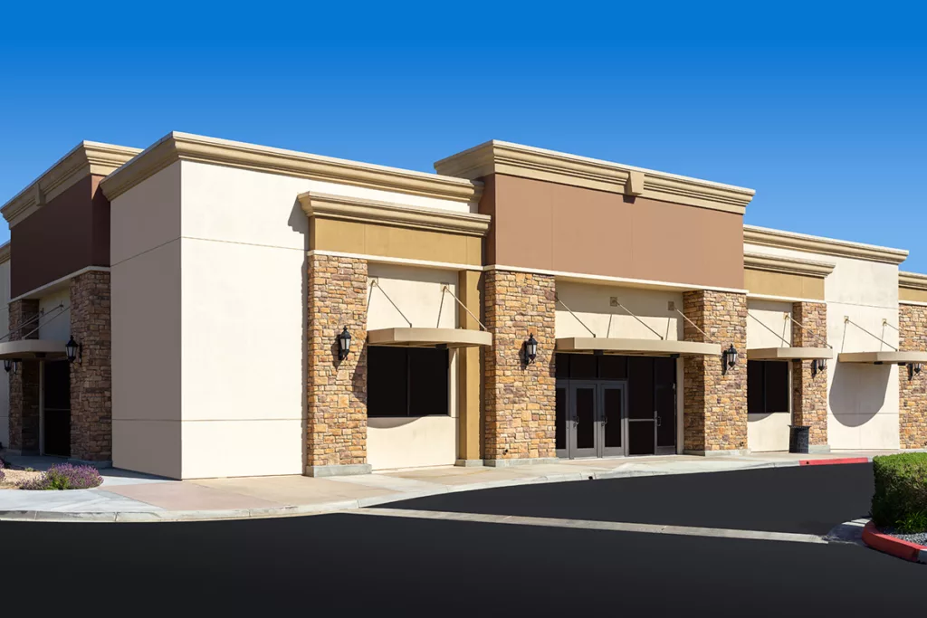 The exterior of a freshly painted commercial building with beige and brown paint.